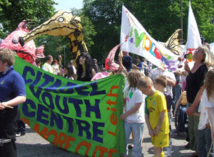 Young people with the yellow Citadel Banner and fish and dragon puppets