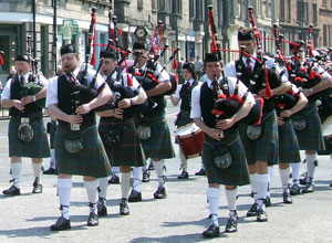 Pipe Band marching in formation in black vest and green and black tartan