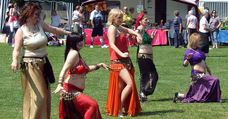 Five women belly dancing in line in various poses