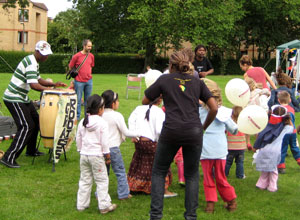 A drummer and dancers with small children and Mums