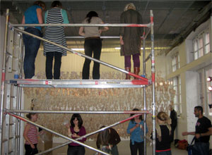 Four women standing on the platform, lookind down at sixe helpers below