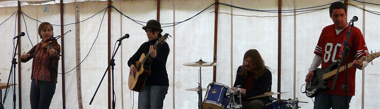 Four piece band - female violinist, female acoustic guitarist (in hat) male drummer and male bassist