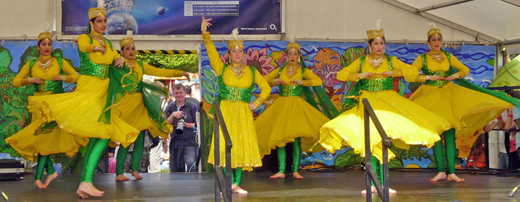 Desi Bravehearts dancing in yellow dresses with yellow headdresses, green waistcoats and green leotards