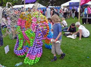 A primary aged boy looks at a sculpture of an elephant made up of brightly coloured balls