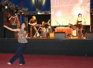 Woman dancing below stage, as band performs
