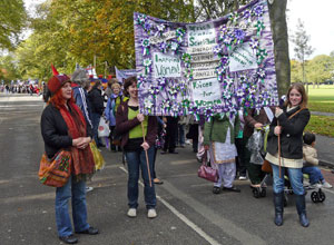 Purple on white banner with rosettes and slogans