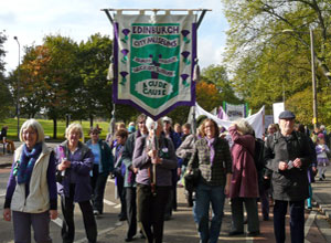 Staff from  Edinburgh City Museums with a 6 foot high banner as the trees start to turn to Autumn