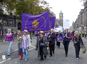 Marchers with the gold on purple EIS banner on Waterloo Place