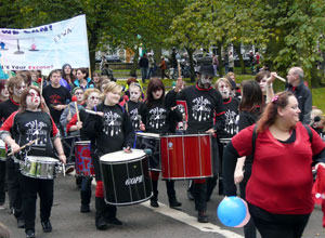 Young people in black with kettle drums