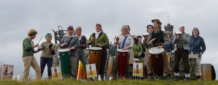 Women dressed as the World War 2 Land Army playing drums and whistles  welcoming people to Calton Hill