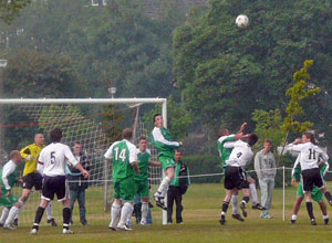 Hibs defender heading the ball to safety