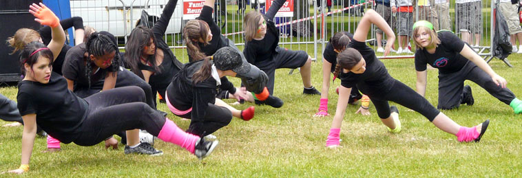 Young people from Open all Hours breakdancing in black outfits with electric pink socks