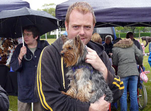 Gary holding a bedraggled  terrier in the rain