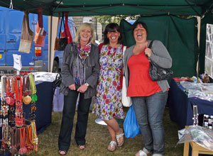 Three women stall holders laughing in their gazebo