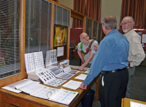 Earnest young man leans forward engaged in discussion with two older men