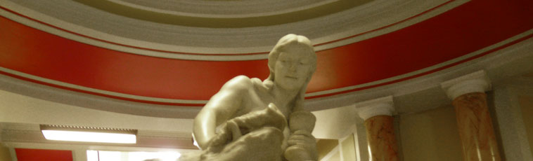 View of the face of the Circe sculpture, with the  red rim  of the foyer's cupola behind
