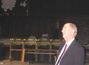 Malcolm looking to the right balcony with the stage behind him