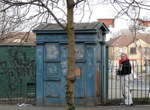 Grafitoed Police Box with Elgin Terrace in the background and a painter in overalls