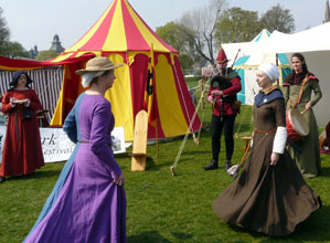 A woman in a purple dress dances with a woman in a brown dress