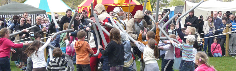 Children with long grey  floppy sticks gleefully attacking encircled knights