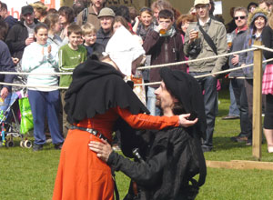 Man in black kneeling before a woman in a xcarlet dress