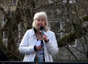 Leslie Riddoch in white jacket speaking from the top of the bus