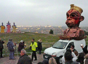 Giant head of Hanuman on the back of a white van with the effigies in the background