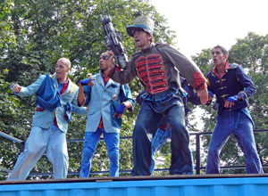 Four men dressed as border guards one of them brandishing a giant bazooka