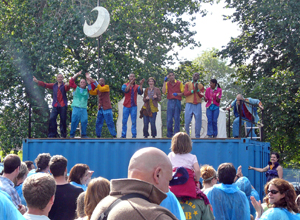 The performers take their bows atop the blue tramsport container with a crescent moon suspended above them