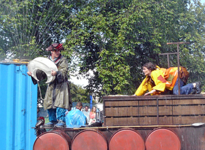 Man in souwester and tricorn  holding the crescent moon as woman watches him on all fours