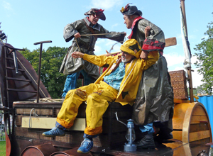Pirates in souwesters and tricorn hats tying up the yellow waterproofed fisheman