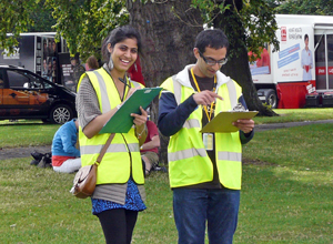 Woman and man in flourescent jsckets with clip boards