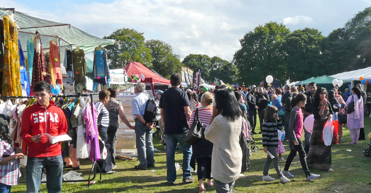 People walking down the avenue of clothes stalls