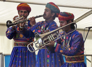 Three men playing a trumpet, a clarinet and a trombone