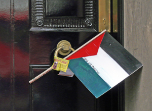 A Palestinian flag with the words "Freedom for Palestine" wedged in the door knocker with a  "Boycott Israeli Goods" sticker