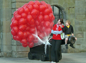 Red balloons in a net tied to a black cannon