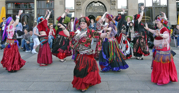 Twisted Tails belly dancers in red, black and purple costumes, with turbans, performing on the Piazza outside Hotel Malmaison in Leith