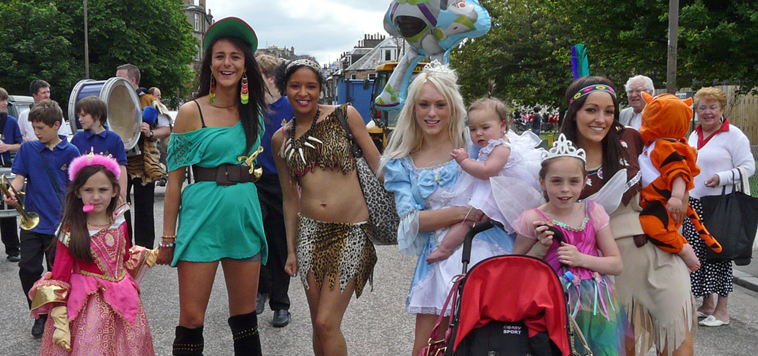 Young women with small girls all dressed up as princesses or Pocahontas