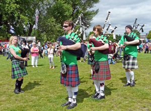 Louise Marshall Millington with a line of three young pipers in green Sunshine on Leith Pipe and Samba Band tee shirts