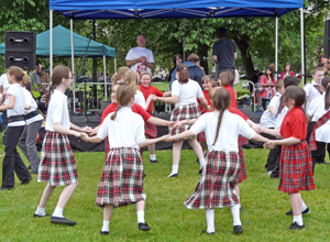 Primary age school children in tartan costumes dancing in a circle