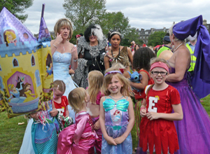 Girls dressed as princessas and majorettes with women in ballgowns and Cruella deVille