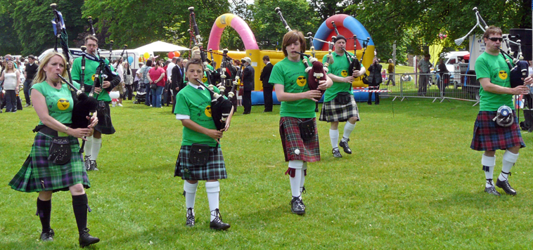 Louise Marshall Millington leads a line of pipers in green Sunshine on Leith tee shirts