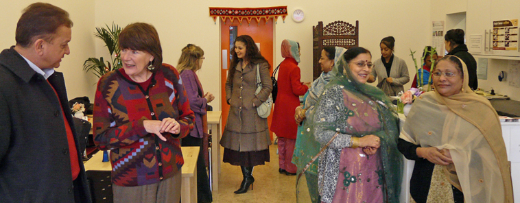 Women and men stand chatting in the cafe area