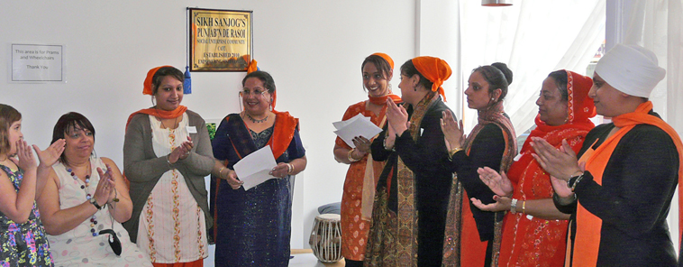 Eight women smiling and applauding Trishna Singh (centre)