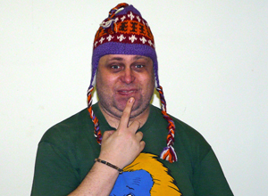Dave wearing a South American woolie hat, with his finger to his lips and a Benny from Crossroads expression