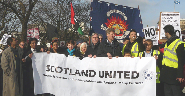ELREC Chair, Shami Khan hold ing the lead banner with poiticians from the major Scottish parties reading "SCOTLAND UNITED  No place for racism and Islamophobia - One Scotland, Many Cultures"