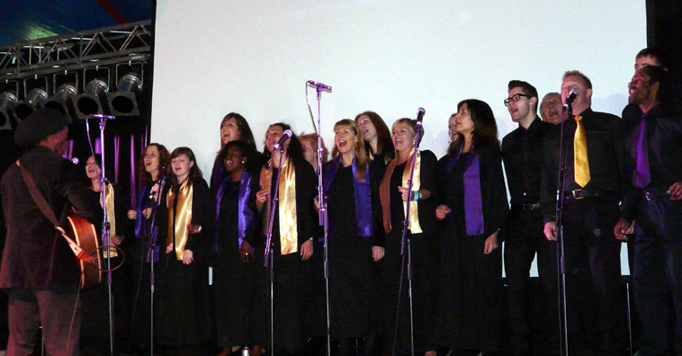 Choir singing, dress in black with gold or purple scarves and ties