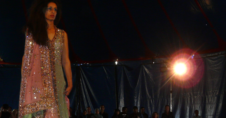 Woman in pink and khaki evening gown walking down the catwalk