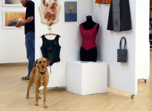 A retriever standing in front of a display of embroidered clothes 