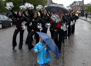 Fierce Pro strike a pose as a little girl in blue twirls her umbrella